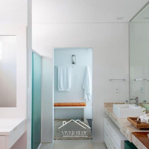 Banheiro moderno com box de vidro, design clean e acabamento refinado.