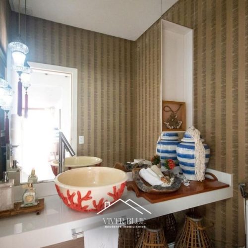 Cozinha gourmet equipada com ilha central, decoração moderna e integração com área social.