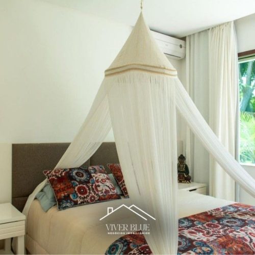 Quarto aconchegante com cama com dossel, decoração leve e iluminação natural.
