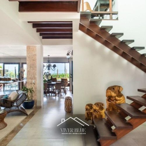 Ambiente interno com escada moderna, integração de espaços e design arquitetônico sofisticado.